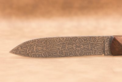 Vue générale : Couteau droit artisanal en damas mosaïque avec manche en bois de fer d'Arizona. Lame : Lame en damas carbone mosaïque forgée artisanalement. Manche : Manche en bois de fer d'Arizona sur couteau artisanal français. Dos : Dos poli d'un couteau à cran forcé fabriqué à la main. Étui : Étui en véritable cuir noir livré avec le couteau artisanal joel alexanian couteau d'art collection damas maison var